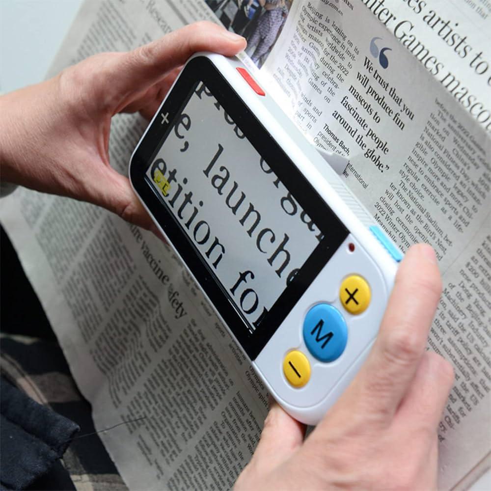 Lupa eletrônica ampliando letras de um jornal.
